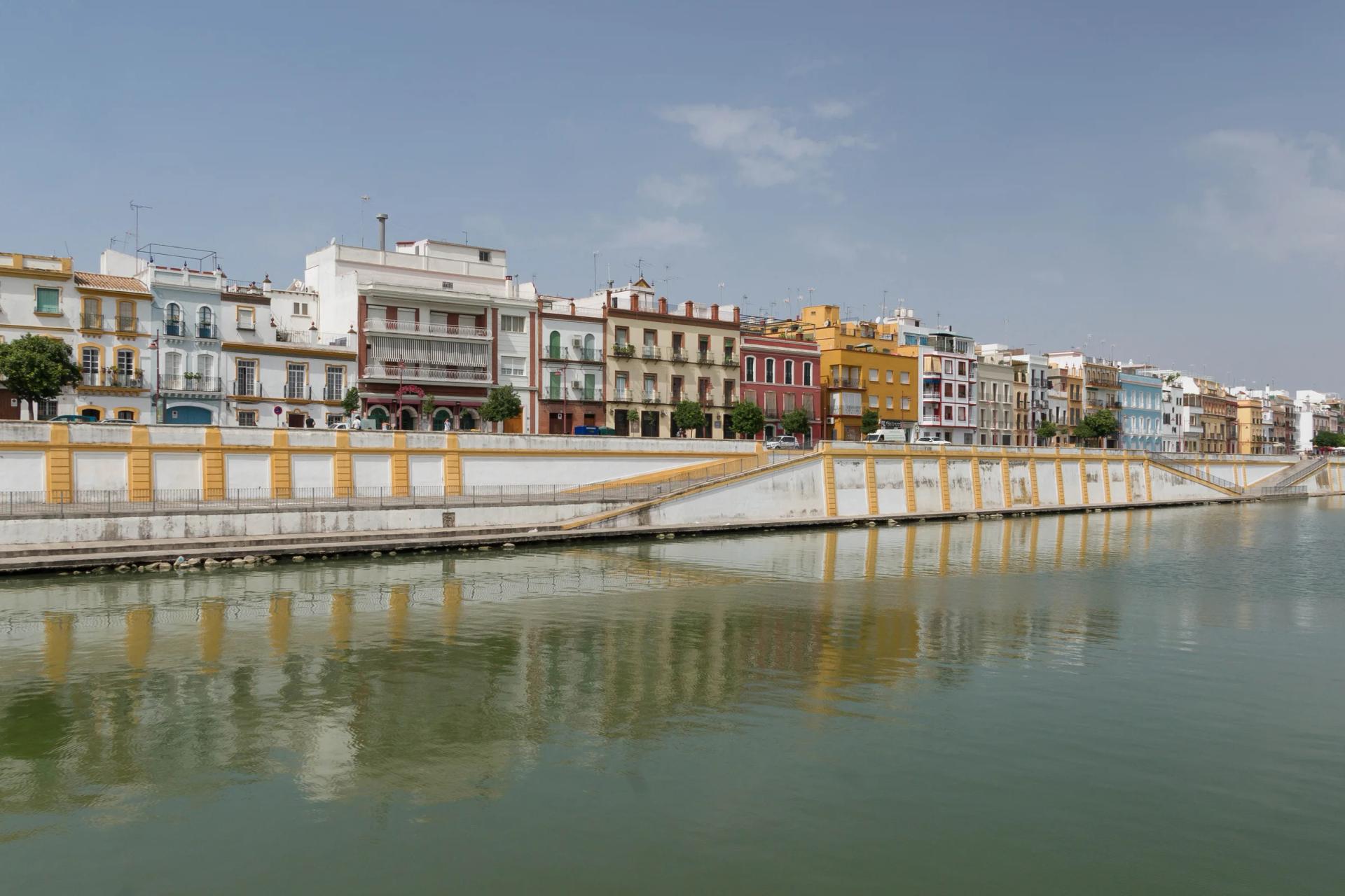 Las fachadas de colores de la calle Betis reflejadas en el Guadalquivir