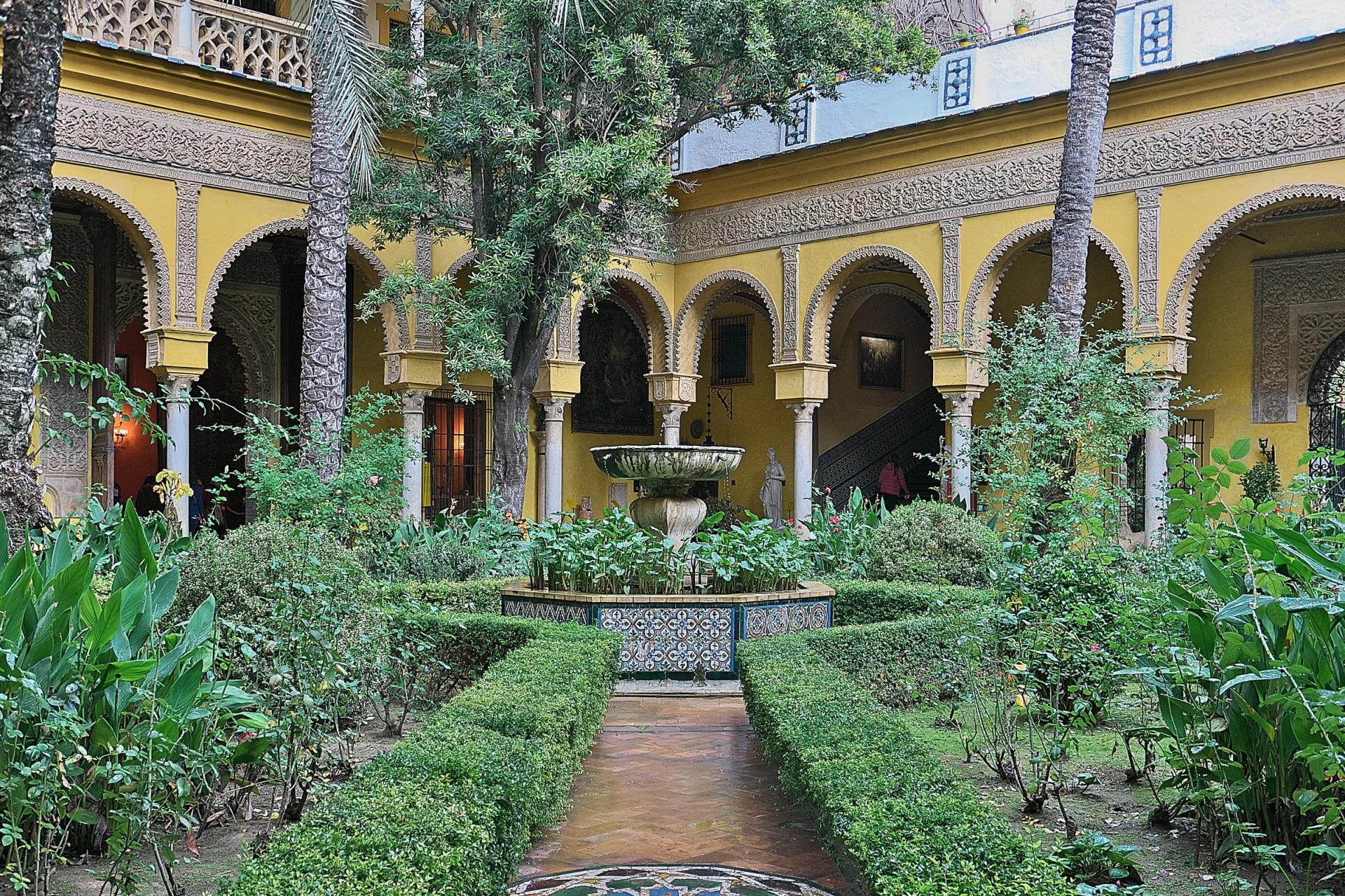 Patio principal del Palacio de las Dueñas, con fuente, setos y galerías