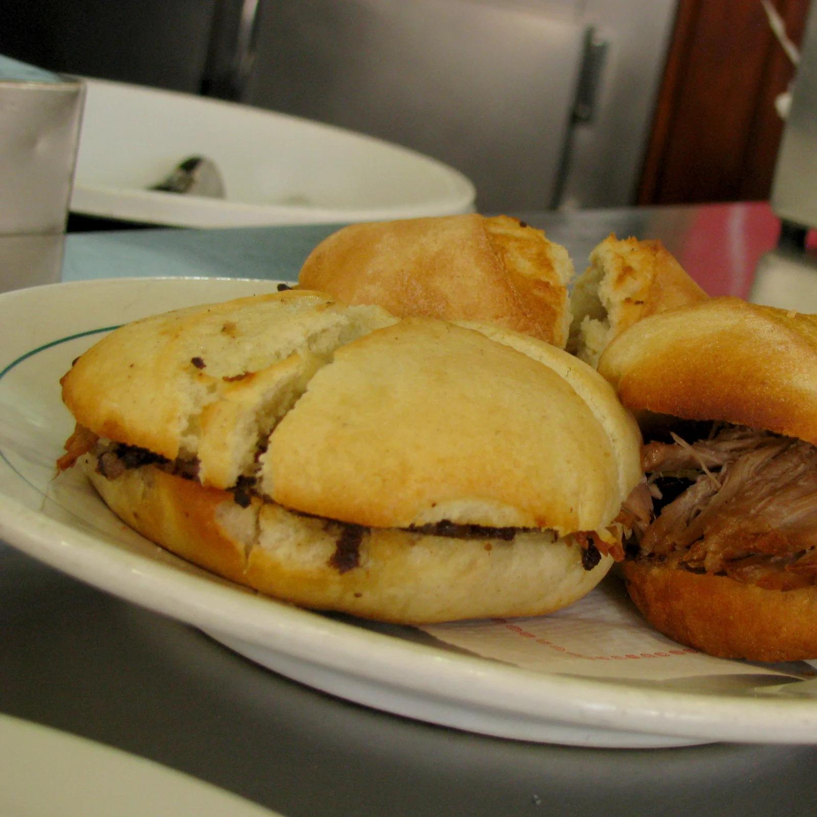 Dos montaditos de pringá en un plato sobre la barra