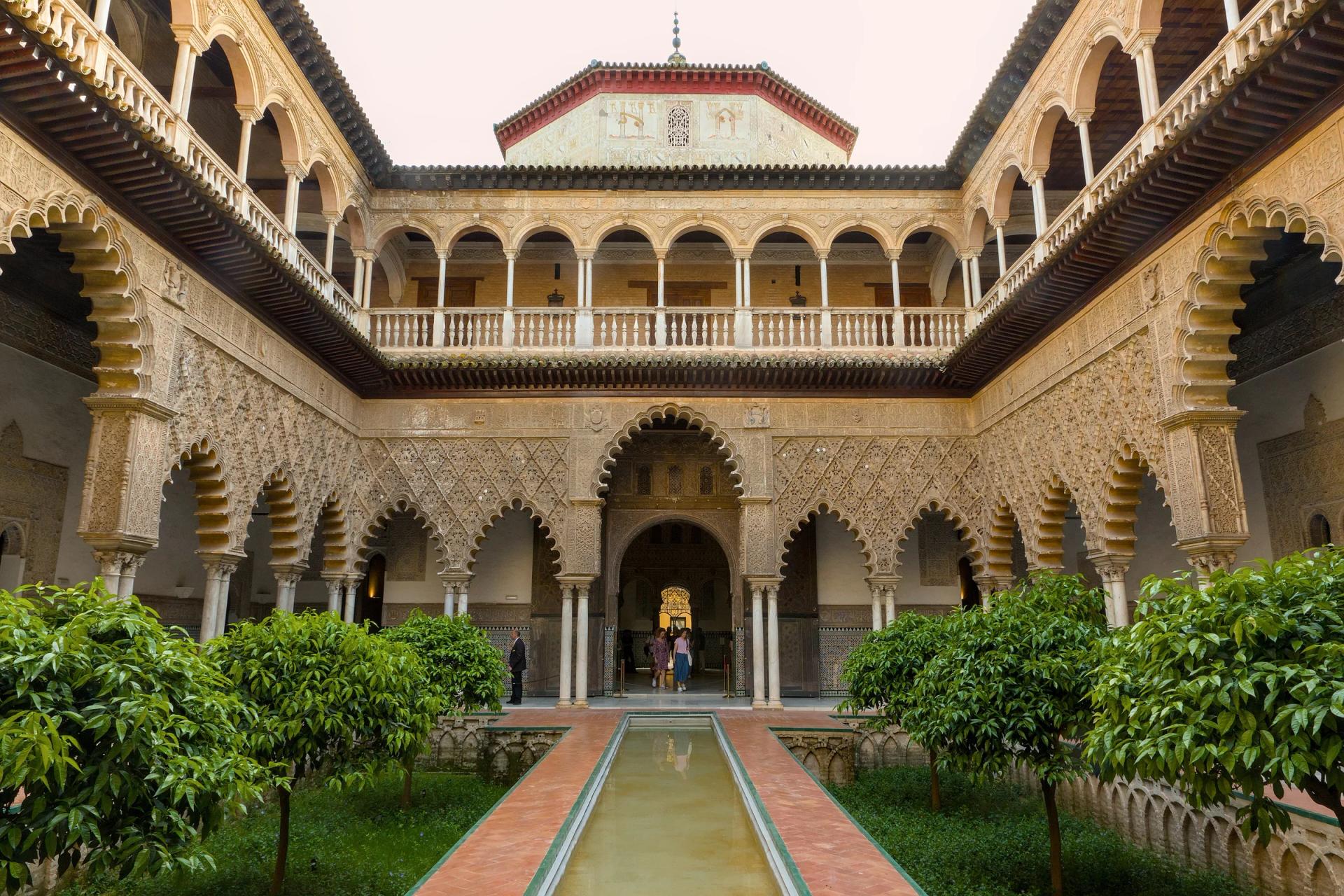 Patio de las Doncellas del Real Alcázar, con su alberca central y arcos de yesería