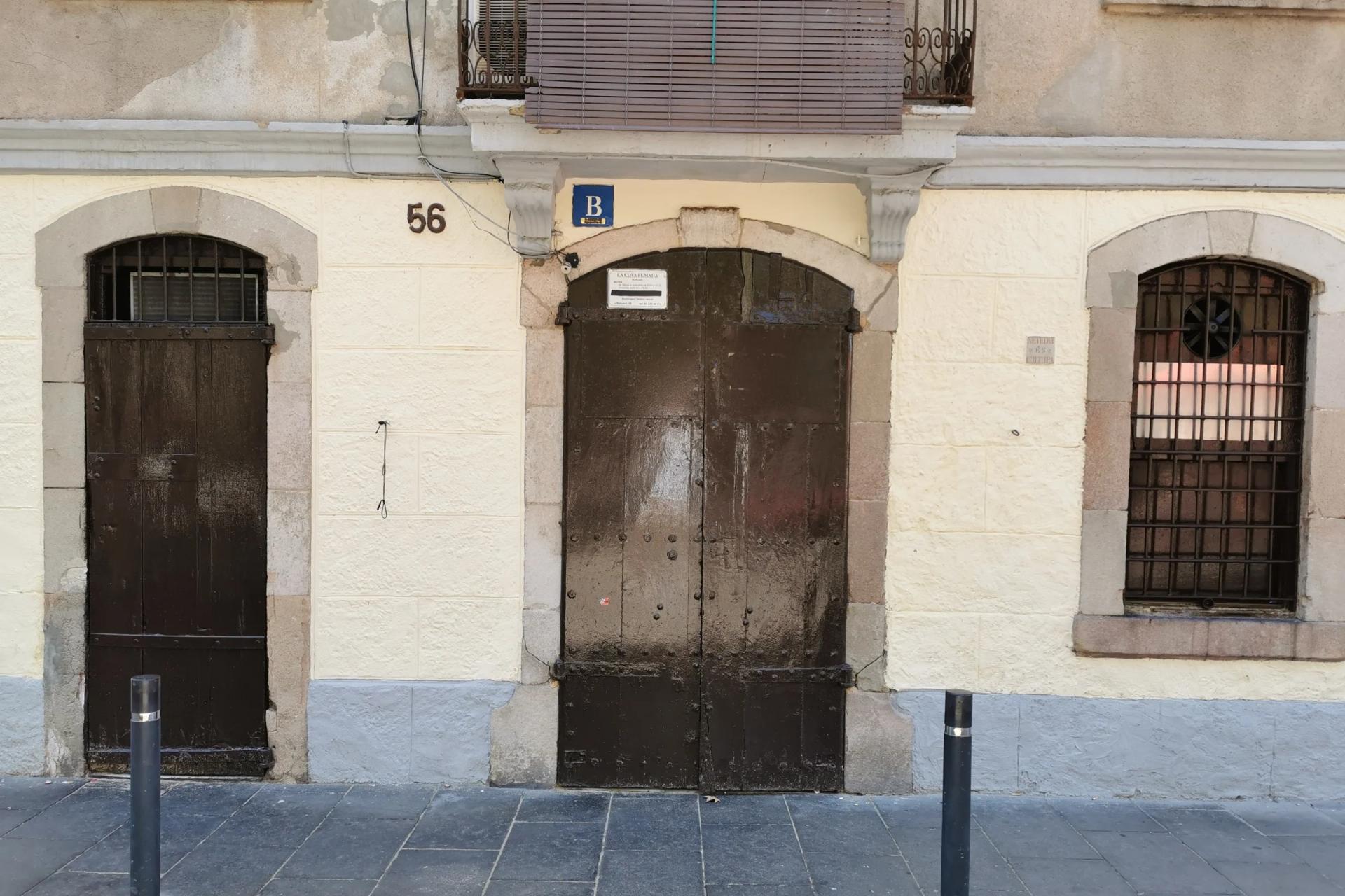 Puertas de madera sin rótulo de La Cova Fumada, en la calle del Baluard de la Barceloneta