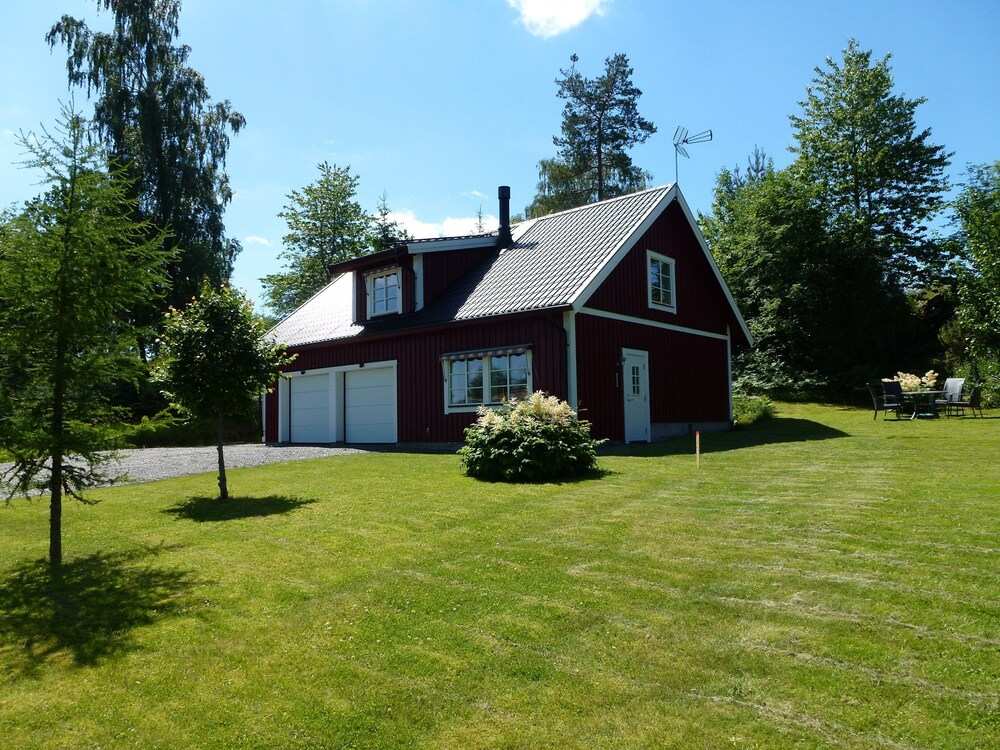 House With An Unique Gathering Of Hunting Trophies. View Of The Pond & Village